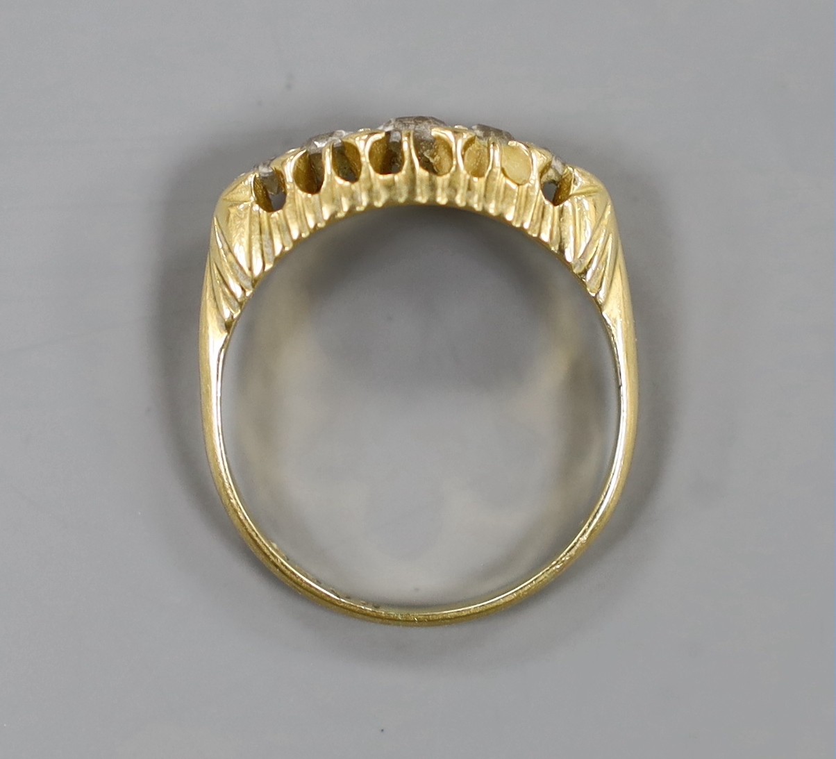 An Edwardian 18ct gold and graduated five stone diamond set half hoop ring, size P, gross weight 4.9 grams.